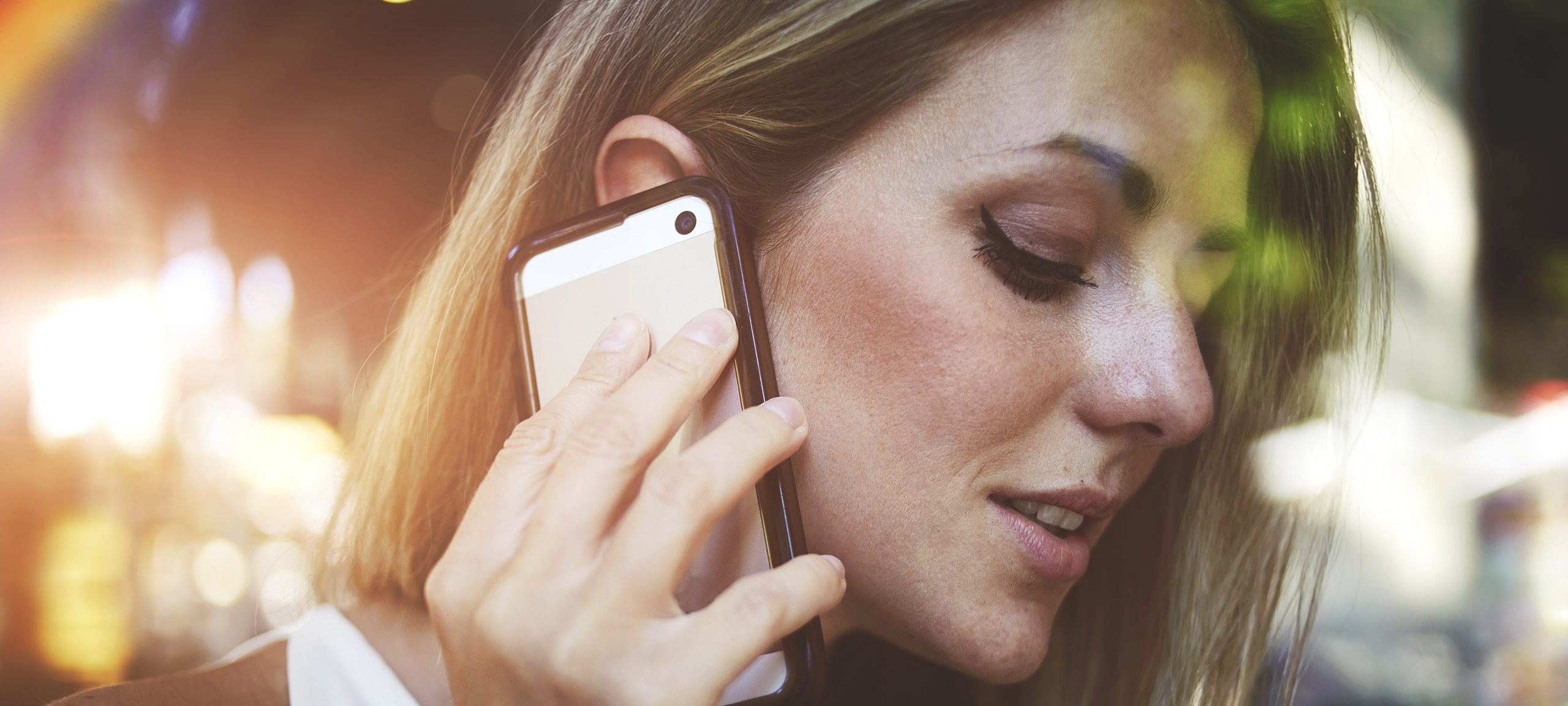 A woman has her phone near her ear
